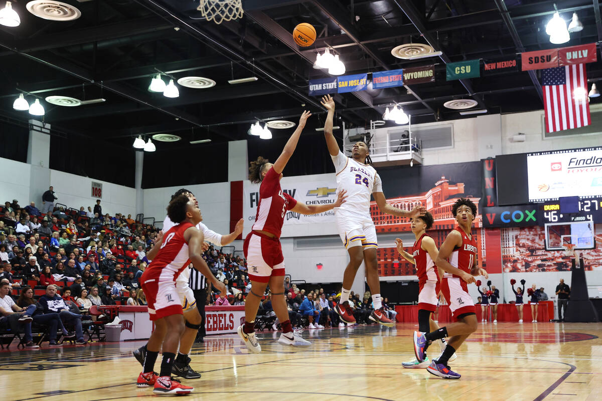 Durango's Taj Degourville (24) shoots the ball under pressure from Liberty's Andre Porter (5) d ...