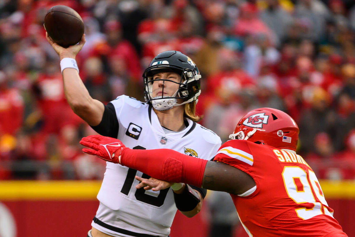 Jacksonville Jaguars quarterback Trevor Lawrence (16) throws while being pressured by Kansas Ci ...