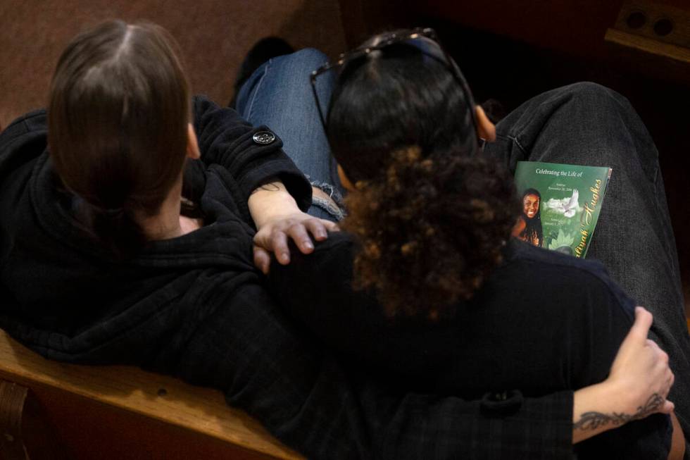 Attendees of a memorial for Ashari Hughes embrace during the service at New Bethel Baptist Chur ...