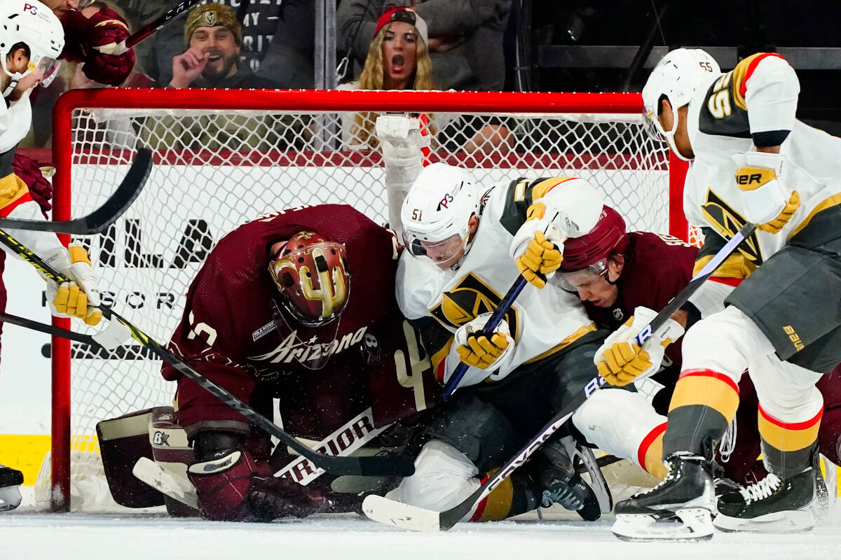 Arizona Coyotes goaltender Karel Vejmelka, left, makes a save against a shot by Vegas Golden Kn ...