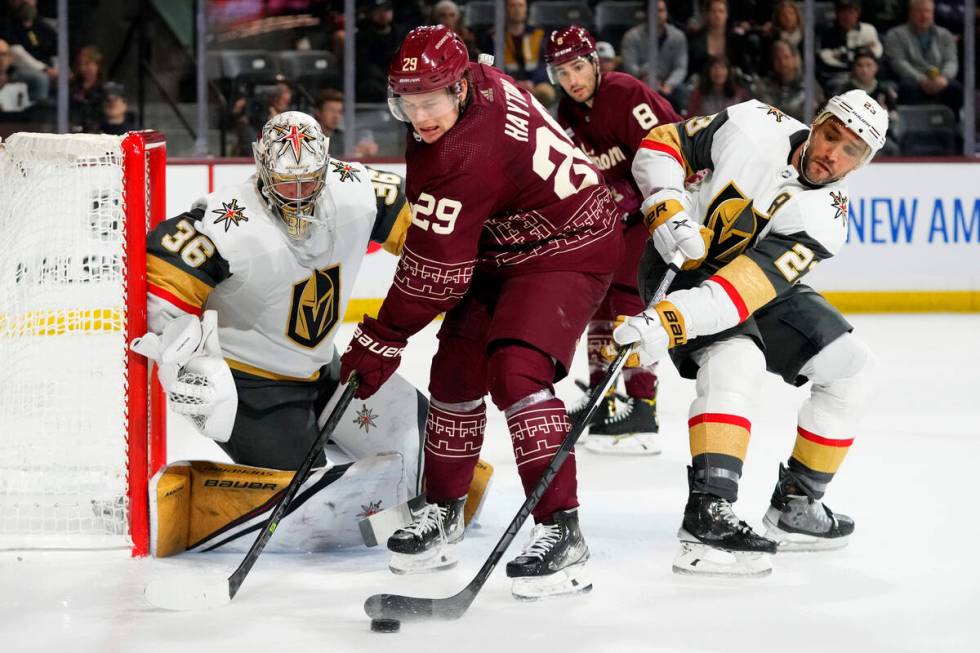 Vegas Golden Knights defenseman Alec Martinez (23) knocks the puck away from Arizona Coyotes ce ...