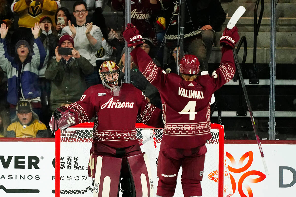 Arizona Coyotes goaltender Karel Vejmelka, left, celebrates after a win over the Vegas Golden K ...