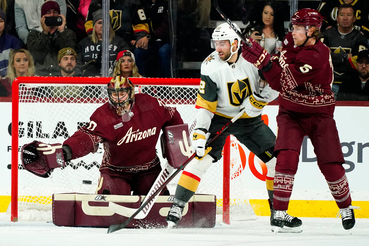 Arizona Coyotes goaltender Karel Vejmelka, left, reaches out to make a save as Vegas Golden Kni ...