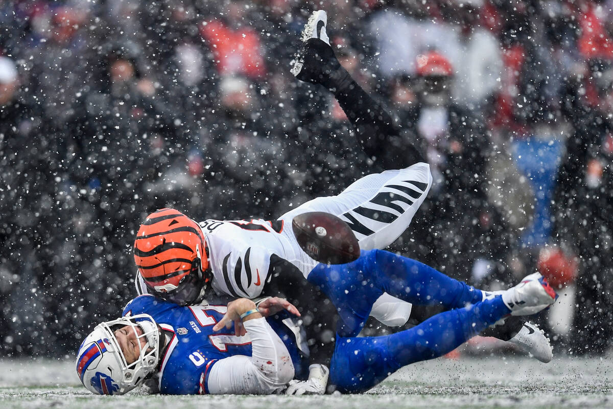 Buffalo Bills quarterback Josh Allen (17) takes a hit from Cincinnati Bengals defensive end Jos ...