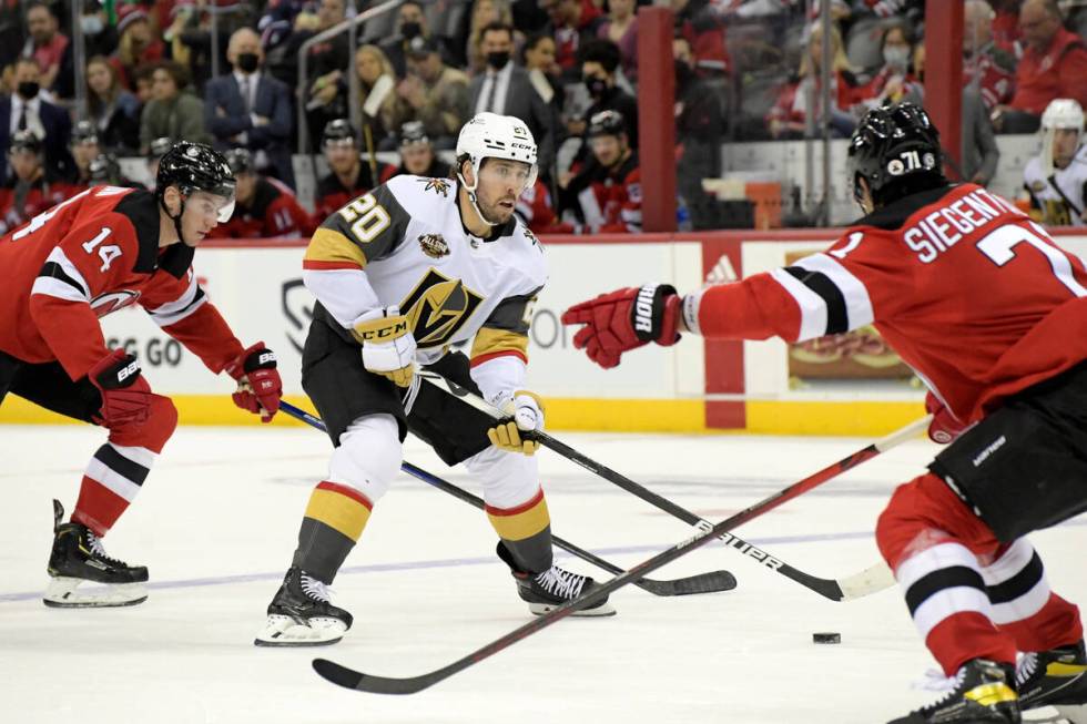 Vegas Golden Knights center Chandler Stephenson (20) looks to pass the puck between New Jersey ...