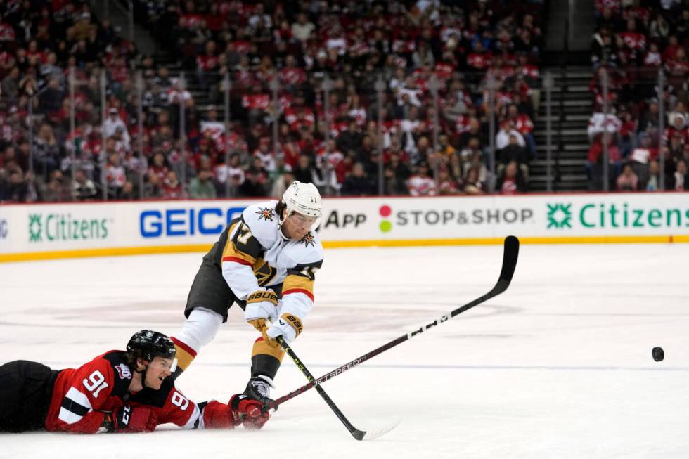 New Jersey Devils center Dawson Mercer (91) fights for the puck against Vegas Golden Knights de ...