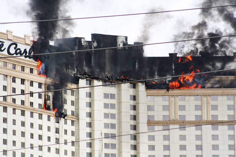 Smoke and flames rise after a fire broke out at the Monte Carlo hotel-casino in Las Vegas on Fr ...