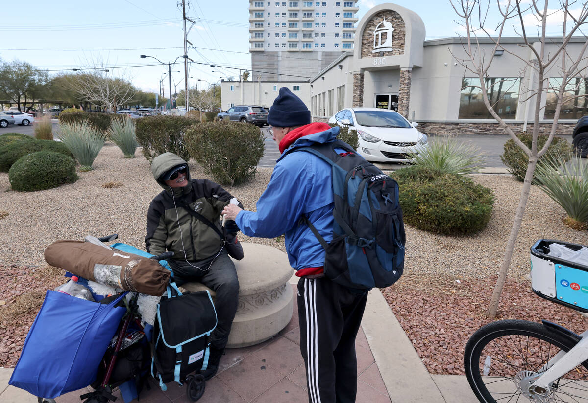 Richard Birmingham, right, offers food to Mike Kelley, 58, during his daily bicycle outreach ri ...