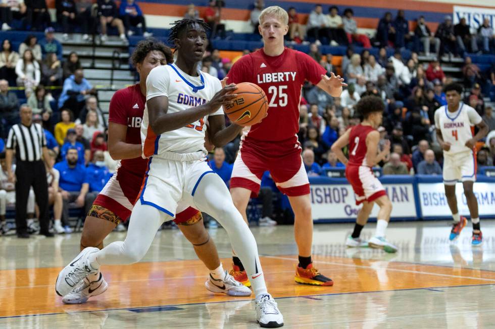 Bishop Gorman’s Chris Nwuli (23) looks to pass while guarded by Liberty’s Andre P ...