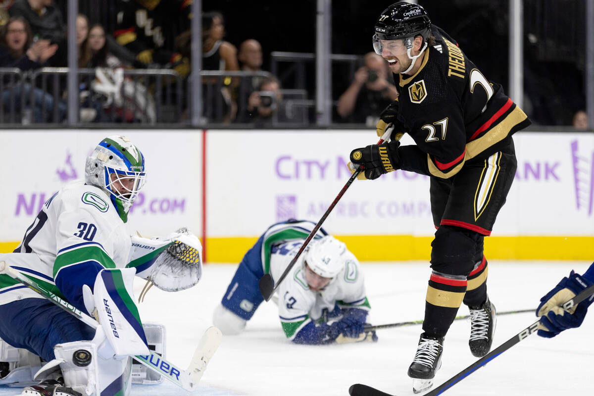 Golden Knights defenseman Shea Theodore (27) attempts a goal while Canucks goaltender Spencer M ...