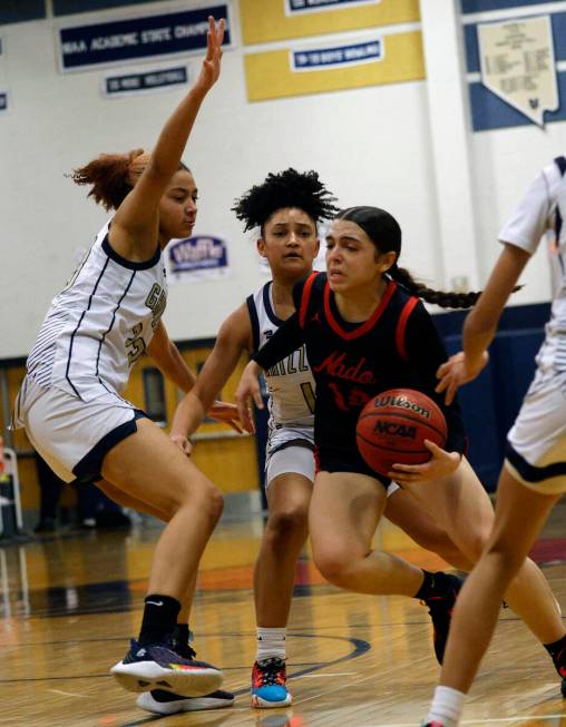 Coronado's Kaylee Walters (14) tries to drive past Spring Valley's Jada Green (23) and Spring V ...