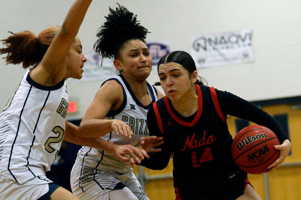 Coronado's Kaylee Walters (14) tries to drive past Spring Valley's Jada Green (23) and Spring V ...