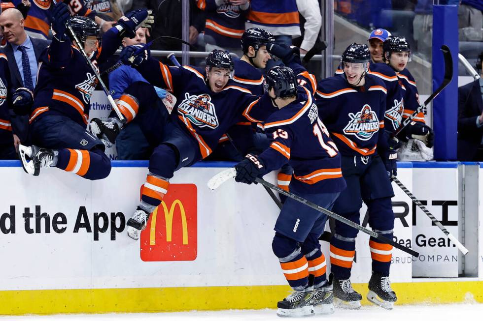 New York Islanders center Mathew Barzal (13) is congratulated by Jean-Gabriel Pageau (44) and t ...