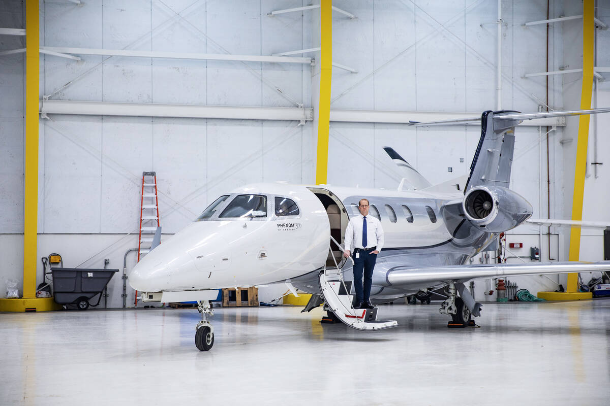Mark Holt, who owns a private aviation business, stands in front of the private jet that he use ...
