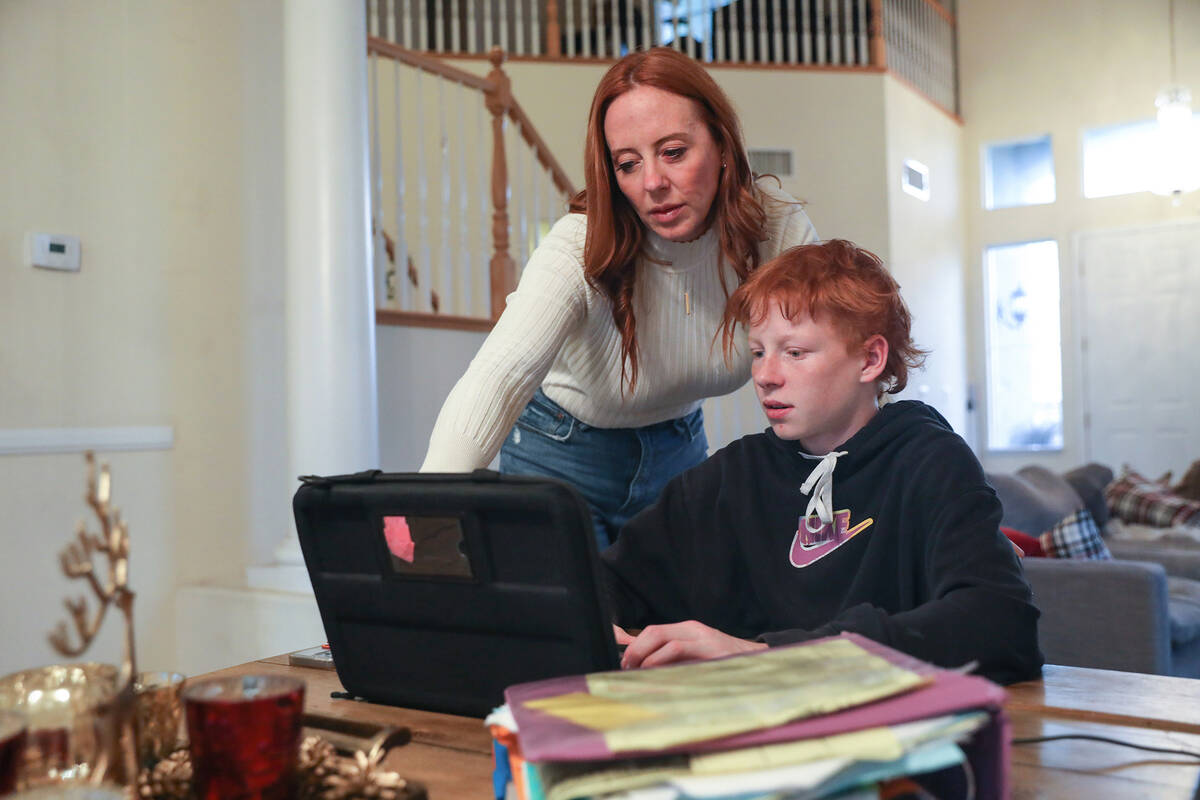 Ann Mabeus helps her son Broch Mabeus, 13, with his homework at their Henderson home. (Rachel A ...