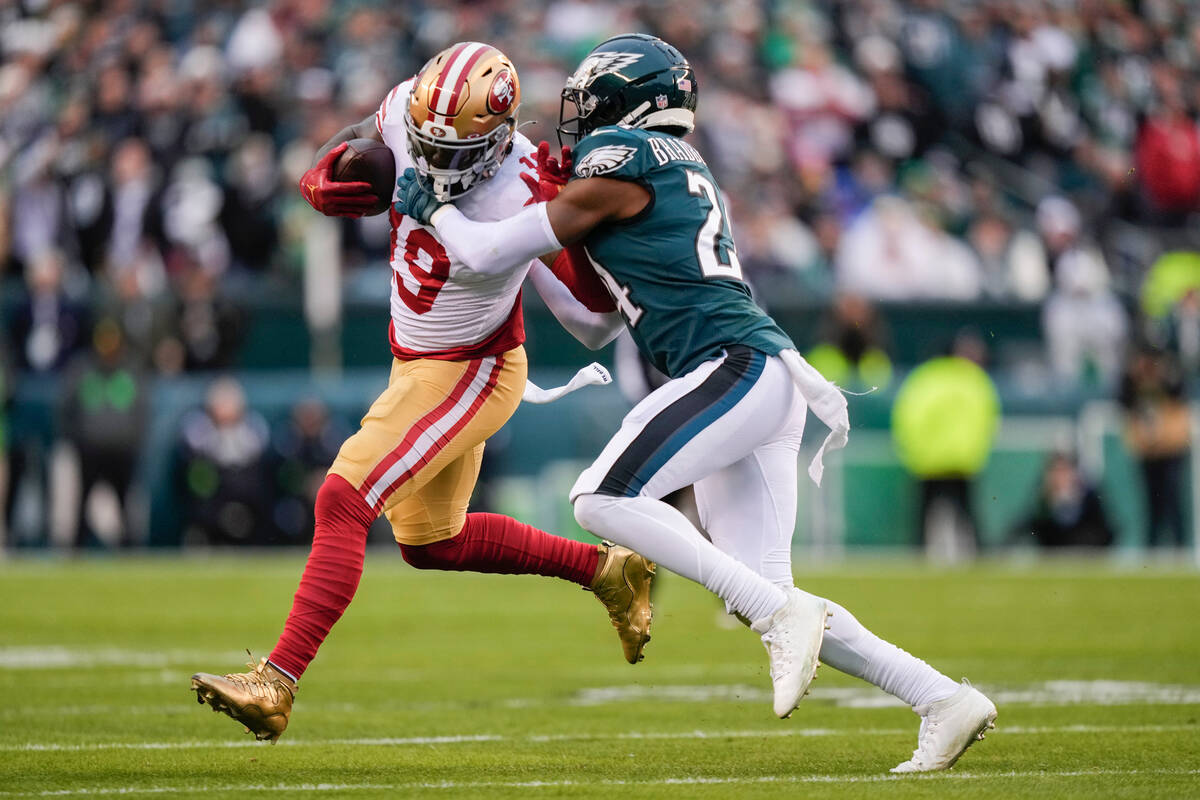 San Francisco 49ers wide receiver Deebo Samuel, left, is tackled by Philadelphia Eagles cornerb ...