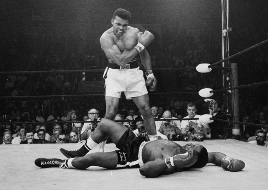 Heavyweight champion Muhammad Ali stands over fallen challenger Sonny Liston, shouting and gest ...