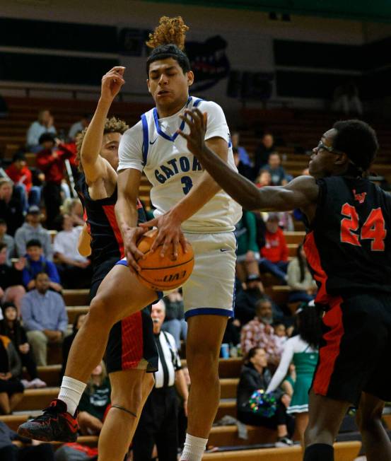 Green Valley's Gaston Zumaya (3) grabs the rebound against Las Vegas' Jordan Massey (0), left, ...