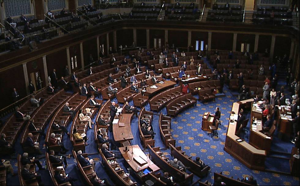 FILE - In this image from video, members of the House practice social distancing as they sit on ...