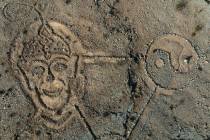 Rocks arranged by an unknown person in the shape of a large triangle with a yin yang at one poi ...