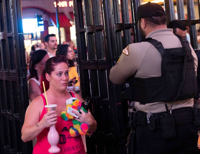 Security officers screen people as they walk through a metal detector before entering the Fremo ...