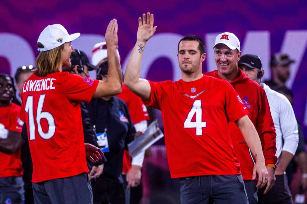 The AFC's Trevor Lawrence (16) with the Jaguars gets a "high five" from Derek Carr (4 ...