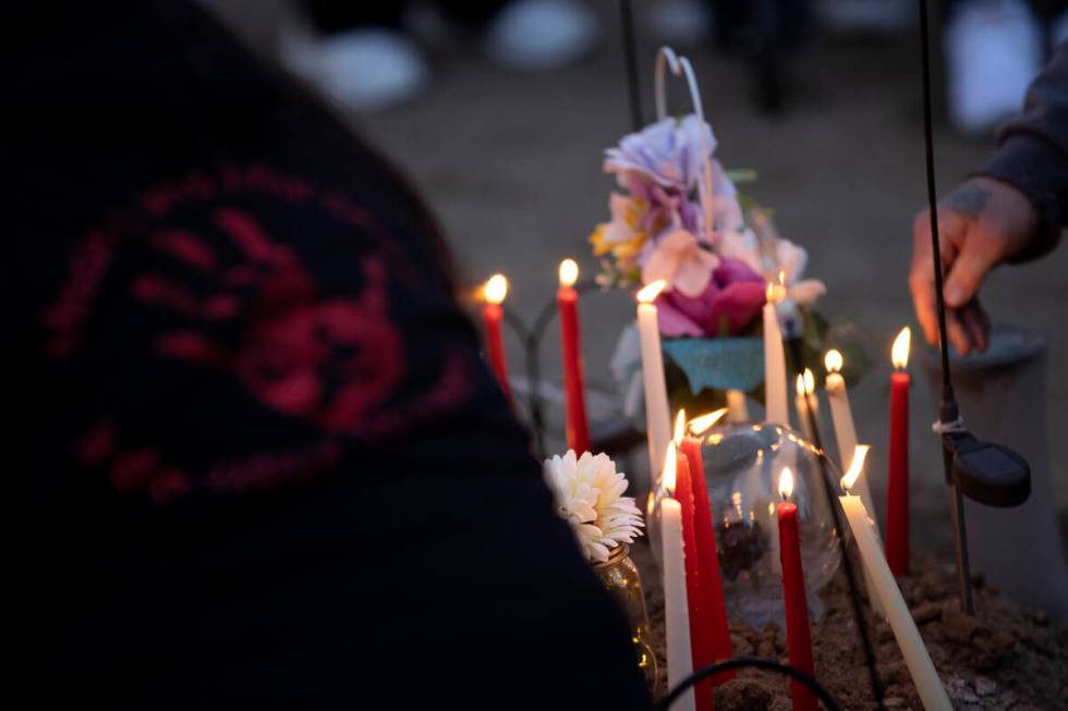 Loved ones of Anna Scott, a member of the Pyramid Lake Paiute Tribe, place candles on her grave ...