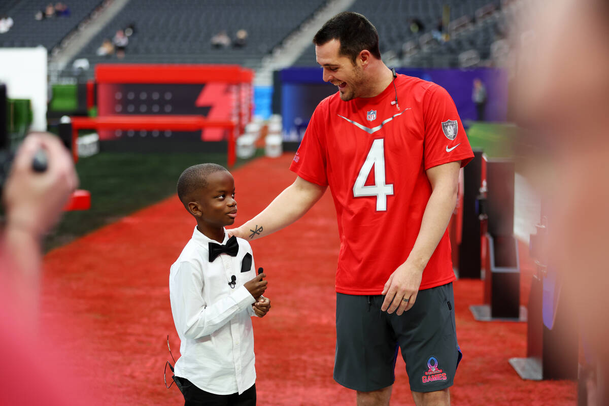 Jeremiah Fennell, 10, left, interviews Las Vegas Raiders quarterback Derek Carr (4) during a Pr ...