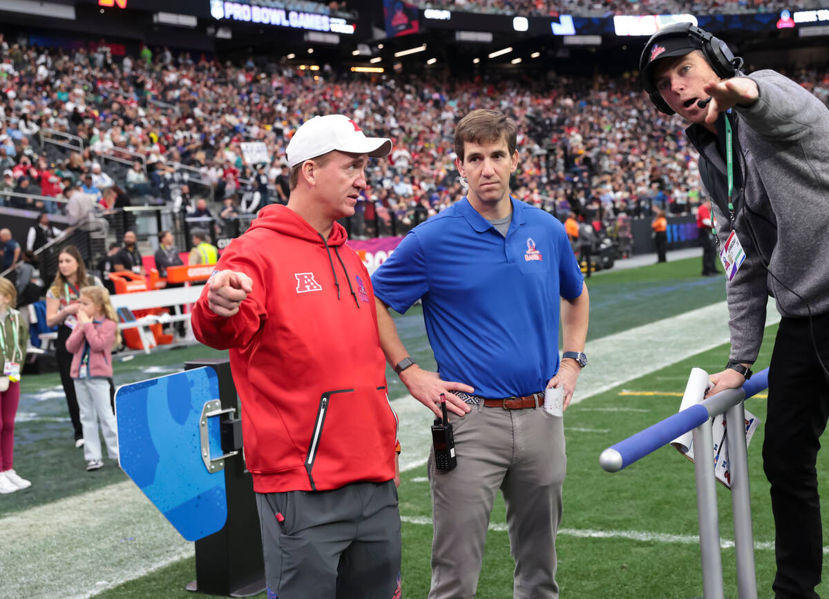 AFC head coach Peyton Manning, left, and NFC head coach Eli Manning listen to the rules of the ...