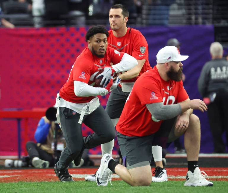 Las Vegas Raiders quarterback Derek Carr (4) hands off the ball to Las Vegas Raiders running ba ...