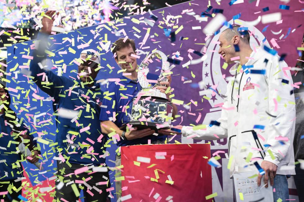 NFC head coach Eli Manning, center, lifts the trophy alongside NFC captain Pete Davidson, right ...