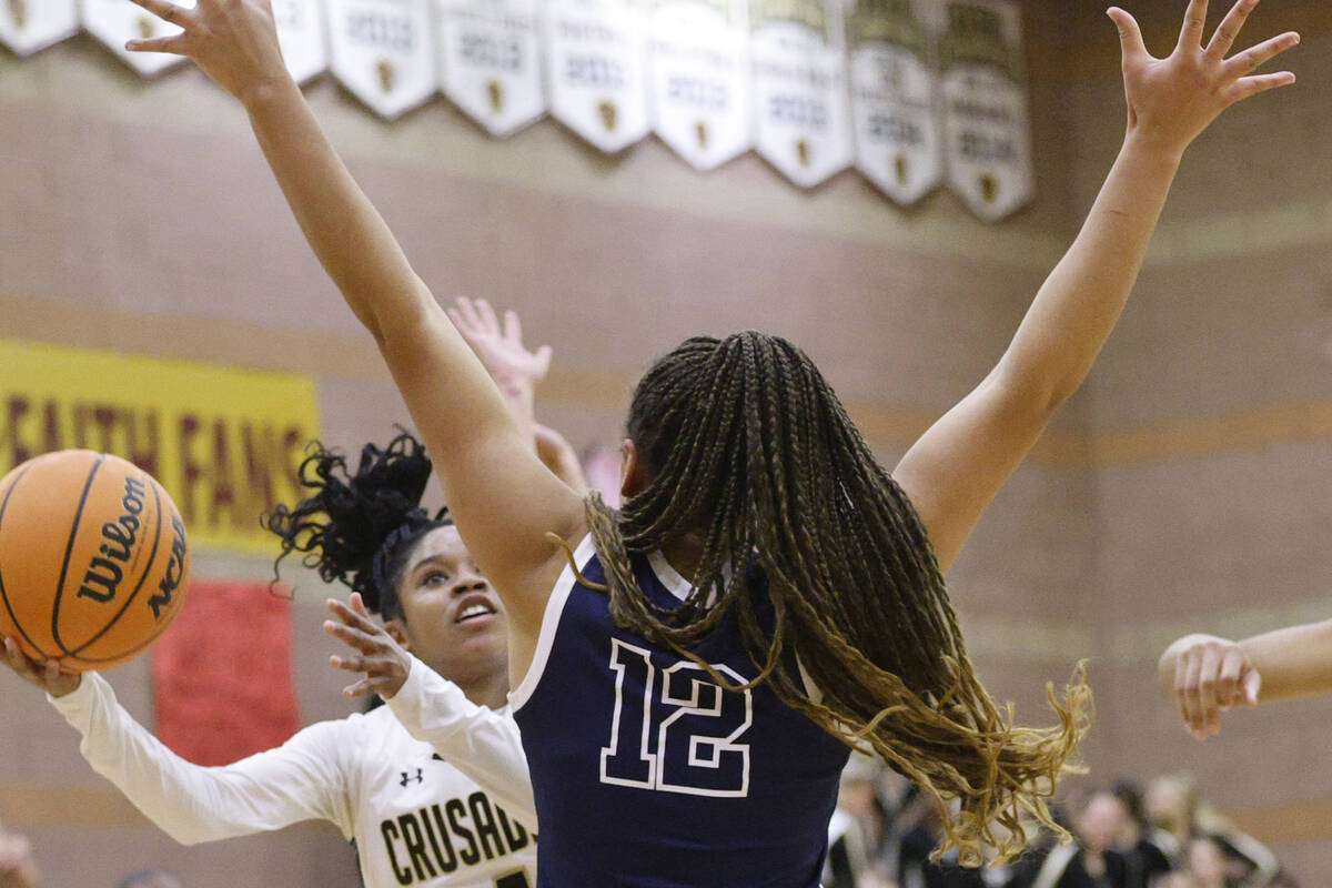 Faith Lutheran's Tamiah Harrison (4) tries to shoot over Centennial's Ayla Williams (12) during ...