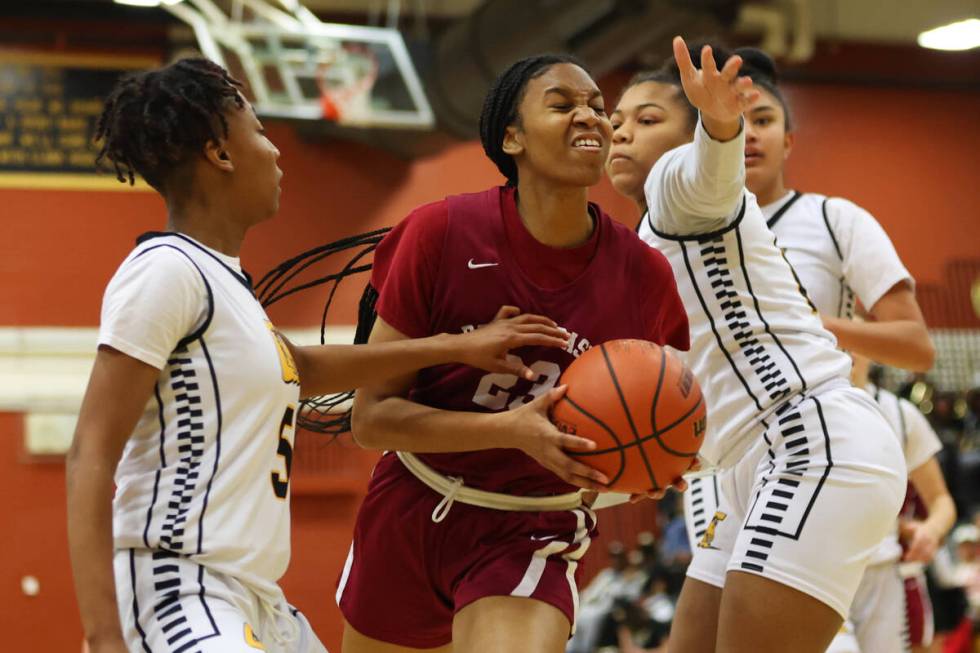 Desert Oasis' Madison Pescado (23) attempts a shot under pressure from Clark's Coryn Theus (5) ...