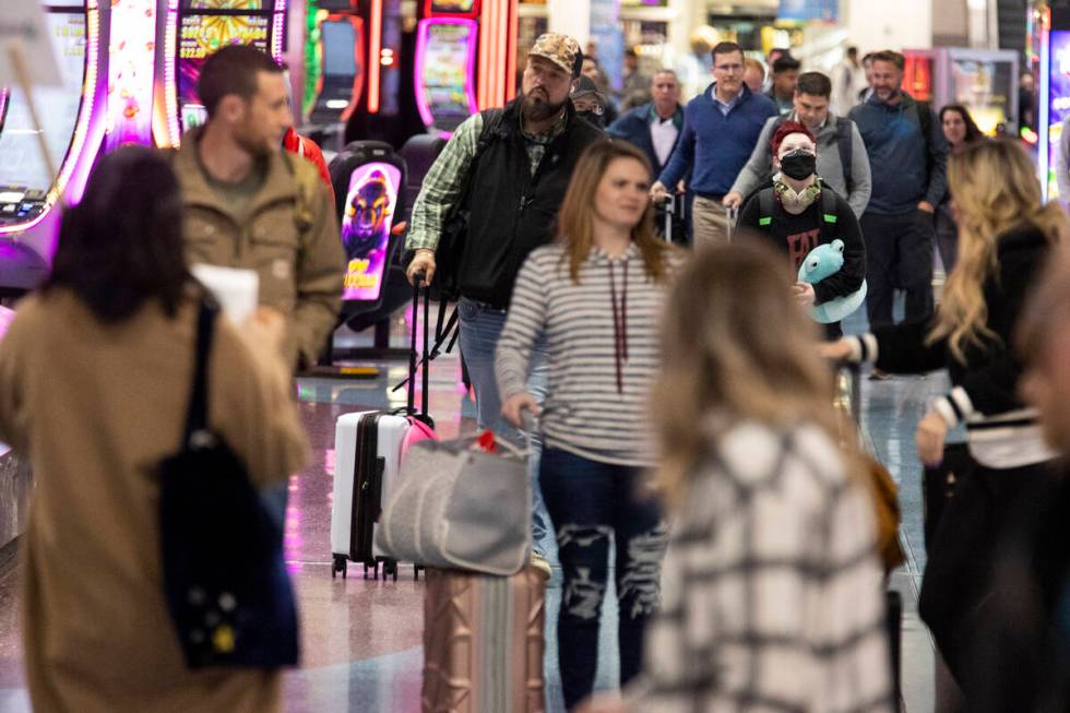 People arrive to the baggage claim area of Terminal 1 at Harry Reid International Airport in La ...