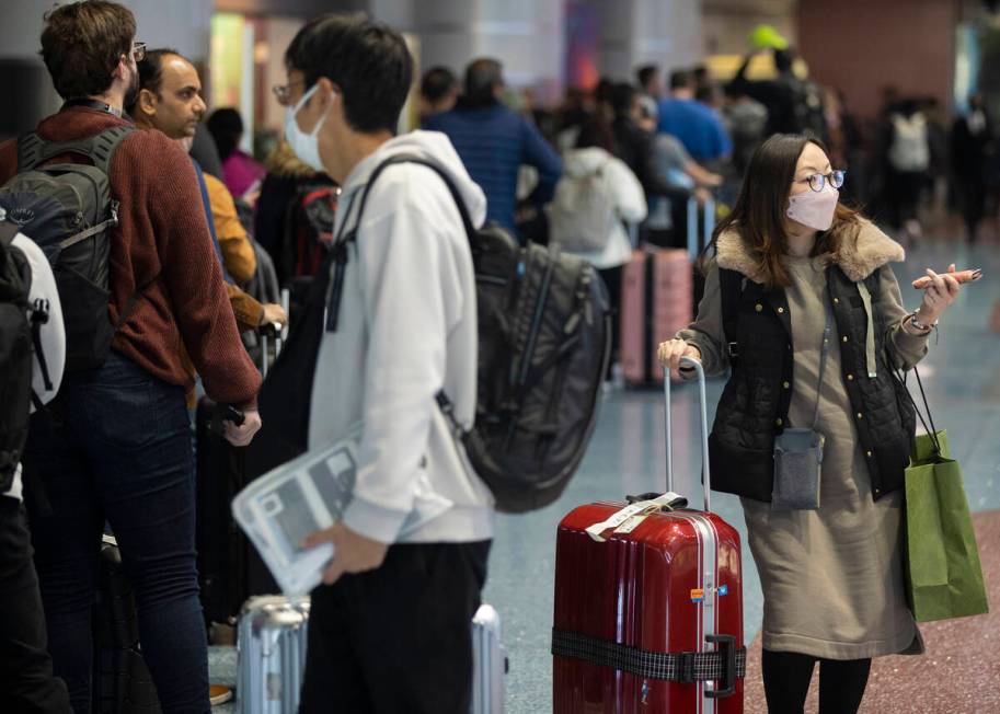 Travelers walk through terminal 1 at Harry Reid International Airport on Sunday, Nov. 27, 2022, ...