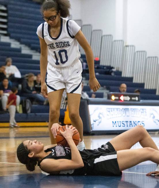 Faith Lutheran's Leah Mitchell (34) protects the ball as Shadow Ridge's Jaslyn Jefferson (10) ...