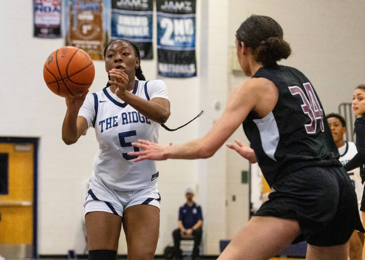 Shadow Ridge's Zh'mya Martin (5) passes the ball as Faith Lutheran's Leah Mitchell (34) defends ...