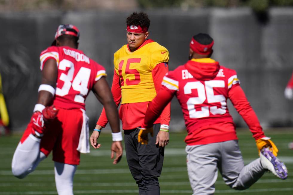 Kansas City Chiefs quarterback Patrick Mahomes (15) stretches with teammates, including running ...