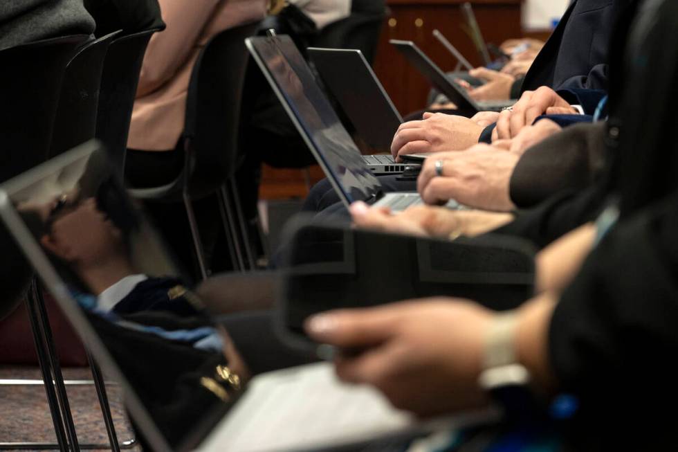 Attendees of a meeting of the Senate Committee on Education use their devices during the 82nd S ...