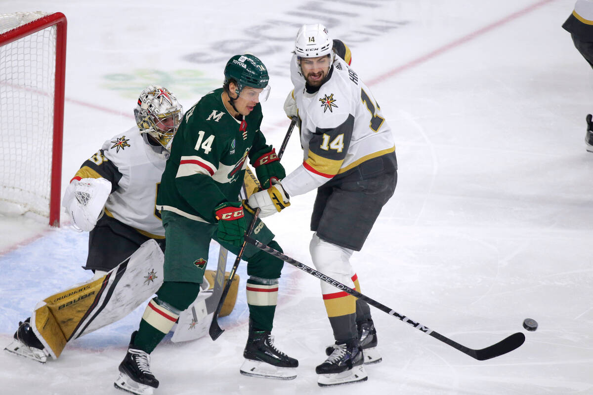 Minnesota Wild center Joel Eriksson Ek (14) looks for the puck with Vegas Golden Knights defens ...