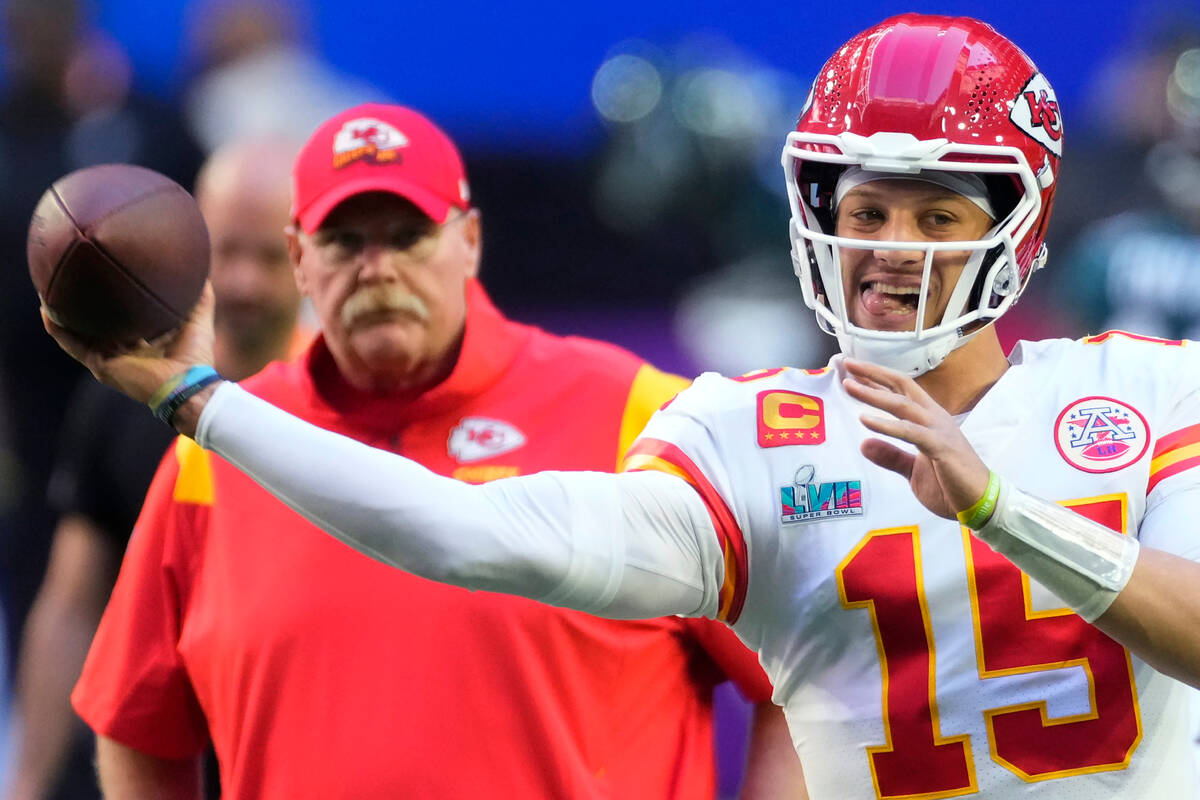 Kansas City Chiefs quarterback Patrick Mahomes (15) warms up as head coach Andy Reid looks on b ...