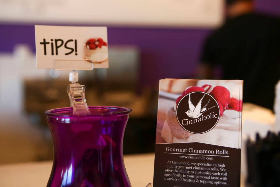 A tip jar is displayed next to menus at Cinnaholic in Las Vegas in 2016. (Chase Stevens/Las Veg ...