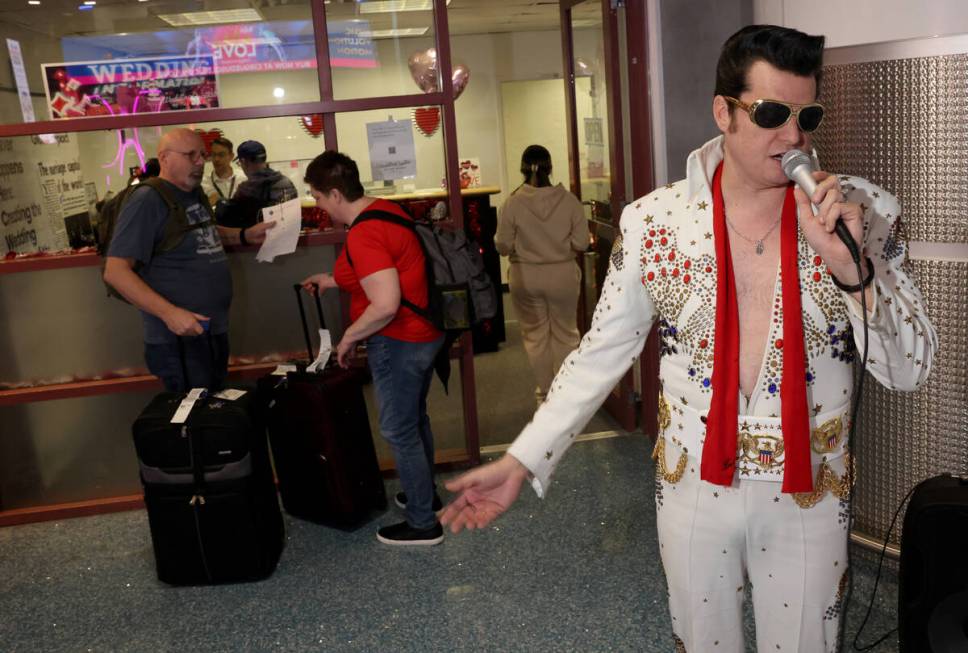 Brian Mills as Elvis sings as wedding couples get their marriage licenses at Harry Reid Interna ...