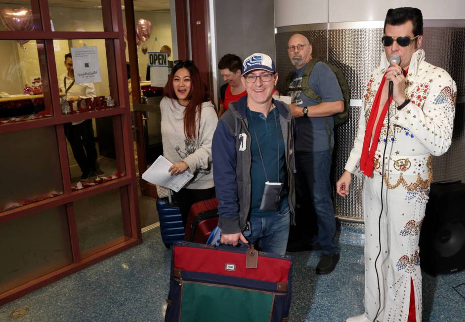 Brian Mills as Elvis sings as Byron Eleniak and Ricel Leigh of Canada get their marriage licens ...