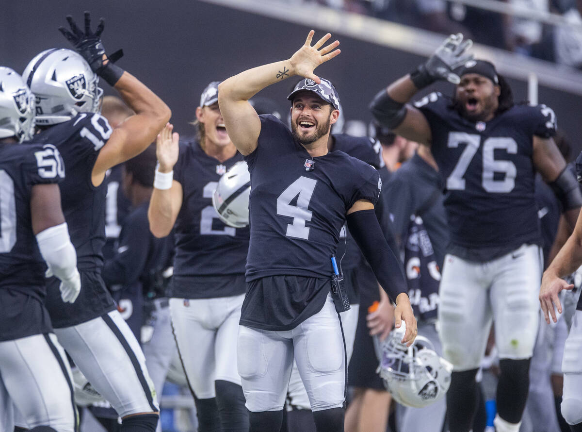 Raiders quarterback Derek Carr (4) jokes with wide receiver Mack Hollins (10) and other players ...