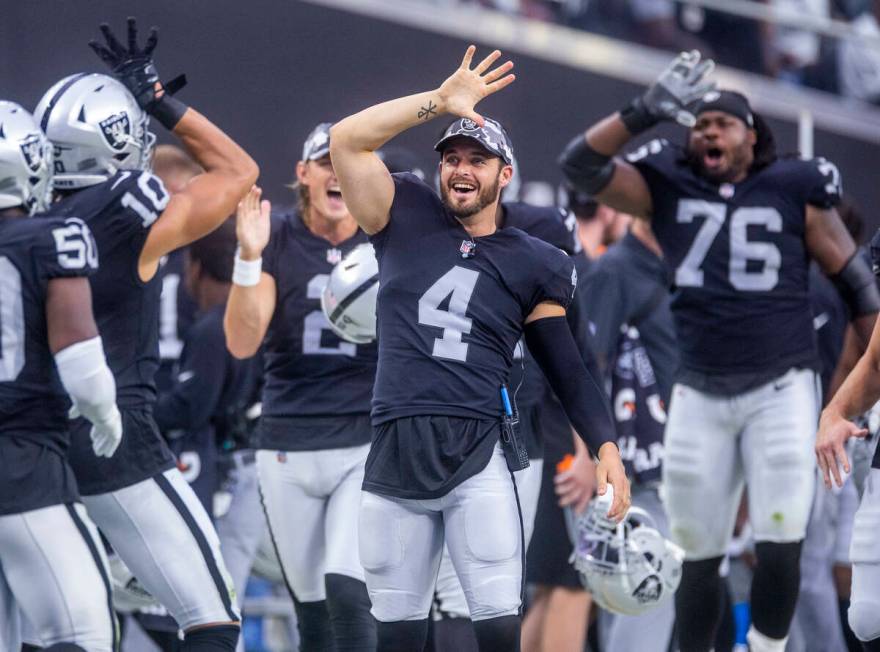 Raiders quarterback Derek Carr (4) jokes with wide receiver Mack Hollins (10) and other players ...