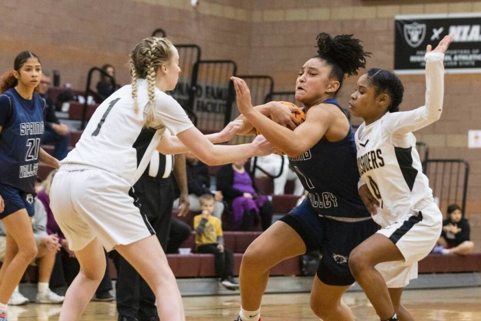 Spring Valley's high Mia Ervin (1) penetrates between Faith Lutheran's Sami Monighetti (1) and ...