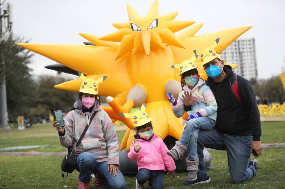 Trainers pose for a photo during a "Pokémon Go Tour" stop in February 2022. The “Pokémon Go ...