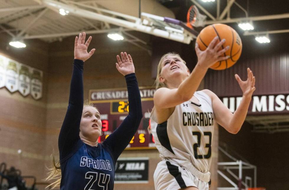 Faith Lutheran's Raina Forgue (23) shoots for the basket as Spring Valley's high Delaney Bartl ...