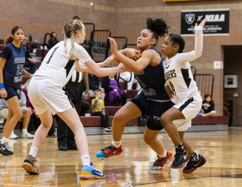 Spring Valley's high Mia Ervin (1) penetrates between Faith Lutheran's Sami Monighetti (1) and ...